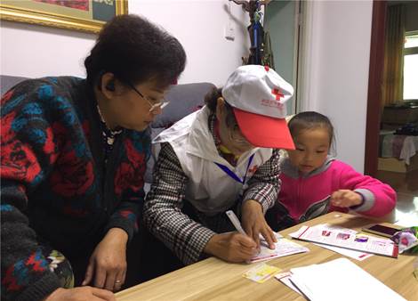 说明:图为志愿者为残疾人指导残疾人填写表格